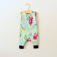 Image showing the Baby/Child Hipster Romper sewing pattern from Elemeno Patterns on The Fold Line. A sleeveless playsuit/romper pattern made in cotton knit fabrics, featuring a round neck, button shoulder fastenings and full length legs with deep ribbed h