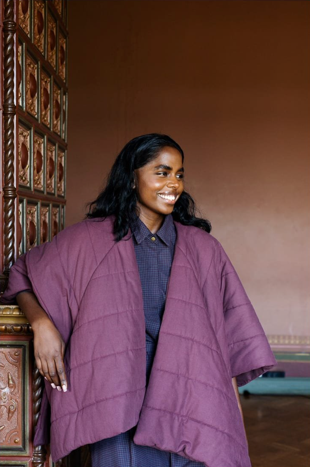 Woman wearing the Hug Cape sewing pattern from TAUKO on The Fold Line. A cape pattern made in non-stretch woven fabrics, featuring a simple design, snap closure, arm slits, no collar and relaxed fit.