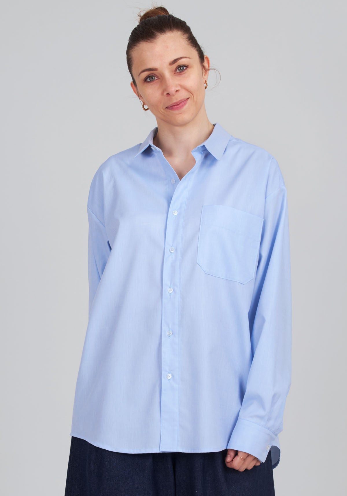 Woman wearing the Unisex Aimé Shirt sewing pattern from I AM Patterns on The Fold Line. A shirt pattern made in poplin, cotton lawn, Oxford cloth, Swiss dot, chambray, cotton or viscose twill, crepe, silk, viscose, double gauze, cotton voile, wax, flannel