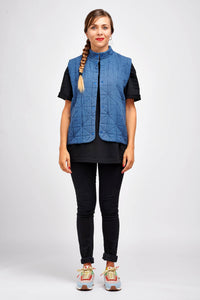 Woman wearing the Hathor Vest sewing pattern from I AM Patterns on The Fold Line. A vest/gilet pattern made in quilted fabric, faux fur, needlecord, boiled wool, denim, gabardine, cotton twill or waxed cotton fabrics, featuring a stand collar, fully lined