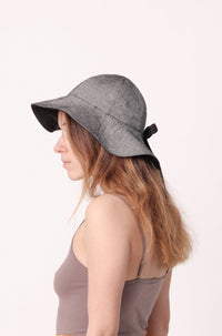 Woman wearing the Ilios Sun Hat sewing pattern from The Patterns Room on The Fold Line. A reversible sun hat pattern made in cotton and cotton blend fabrics, featuring a classic brim and back ribbon bow.