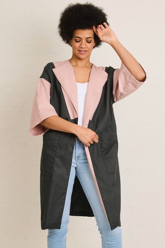 Woman wearing the Inez Summer Jacket sewing pattern from Atelier Jupe on The Fold Line. A jacket pattern made in viscose, tencel, cotton, linen, or polyester fabric, featuring a relaxed knee-length silhouette, wide half-length sleeves, large topstitched f