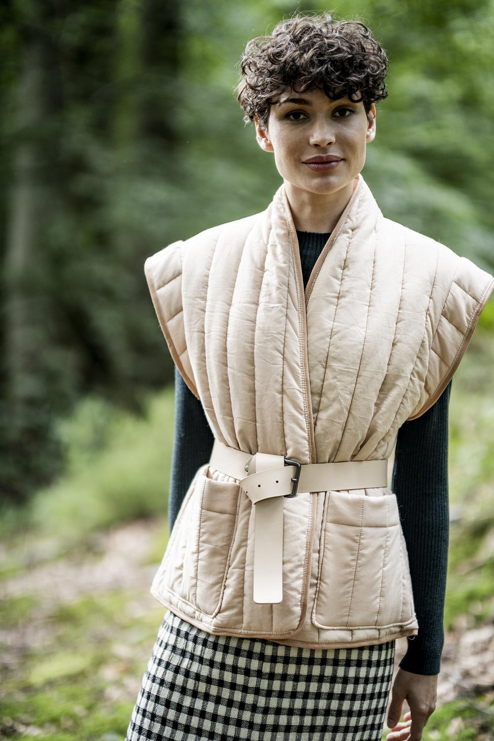 Woman wearing the Irma Bodywarmer sewing pattern from Fibre Mood on The Fold Line. A gilet pattern made in padded, quilted or sweatshirt fabrics, featuring patch pockets, bias tape edging and capped sleeve.