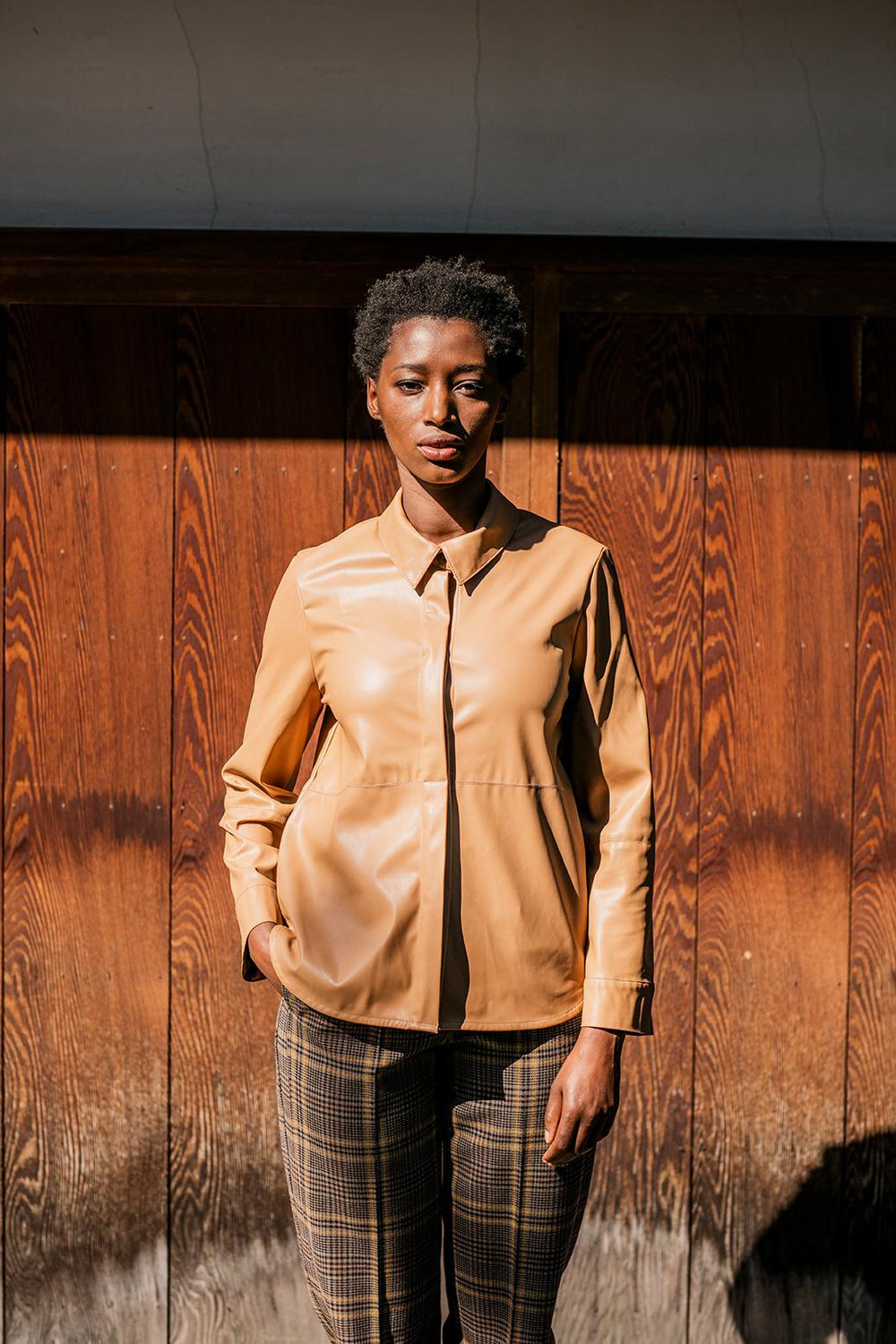 Woman wearing the Isra Shirt sewing pattern from Fibre Mood on The Fold Line. A shirt pattern made in leather(ette), suede(tte), denim, poplin, linen or Tencel fabrics, featuring a minimalistic cut, hidden button placket, straight set in sleeves, collar a