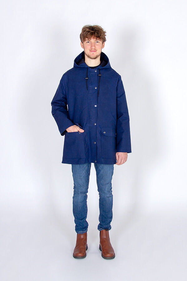 Man wearing the Men's Jacques Raincoat sewing pattern from I AM Patterns on The Fold Line. A raincoat pattern made in water-resistant and waterproof fabrics, gabardine, waxed cotton, wool coating, cotton serge, cotton twill, denim or corduroy fabrics, fea