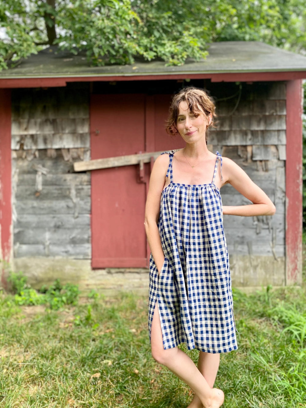 Woman wearing the Jane Dress sewing pattern from Marsha Style on The Fold Line. A dress pattern made in linen, cotton lawn, voile, batiste, poplin or viscose fabrics, featuring an above knee length, A-line silhouette, long shoulder ties, gathered bound ne