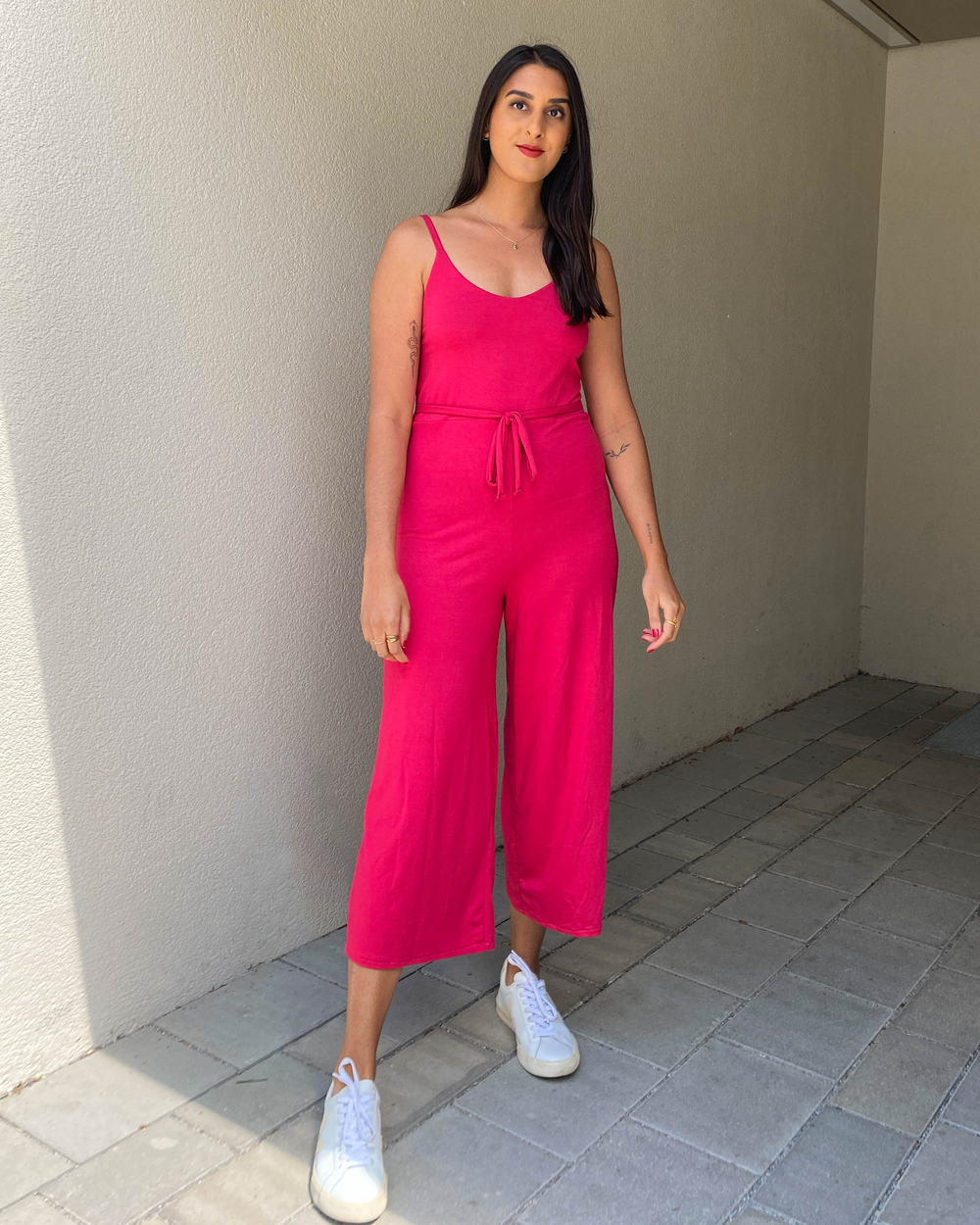 Woman wearing the Jaya Jumpsuit sewing pattern from Tammy Handmade on The Fold Line. A jumpsuit pattern made in 2-way stretch knit fabric such as jersey, ribbed knit or stretch velvet fabrics, featuring spaghetti straps, waist ties, slip-on design, no fas