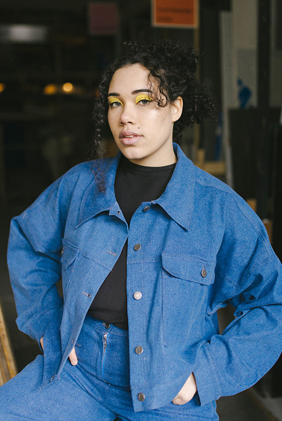 Woman wearing the Jean Jacket sewing pattern from JULIANA MARTEJEVS on The Fold Line. A denim jacket pattern made in stretch denim fabrics, featuring an oversized fit, dropped shoulders, front patch pockets, side slash pockets, double topstitching and cro