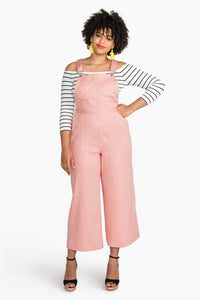 Woman wearing the Jenny Overalls sewing pattern from Closet Core Patterns on The Fold Line. A dungaree pattern made in denim, twill, canvas, gabardine, medium weight linen, jacquard or brocade fabrics, featuring wide legged trousers, ultra-high rise, util