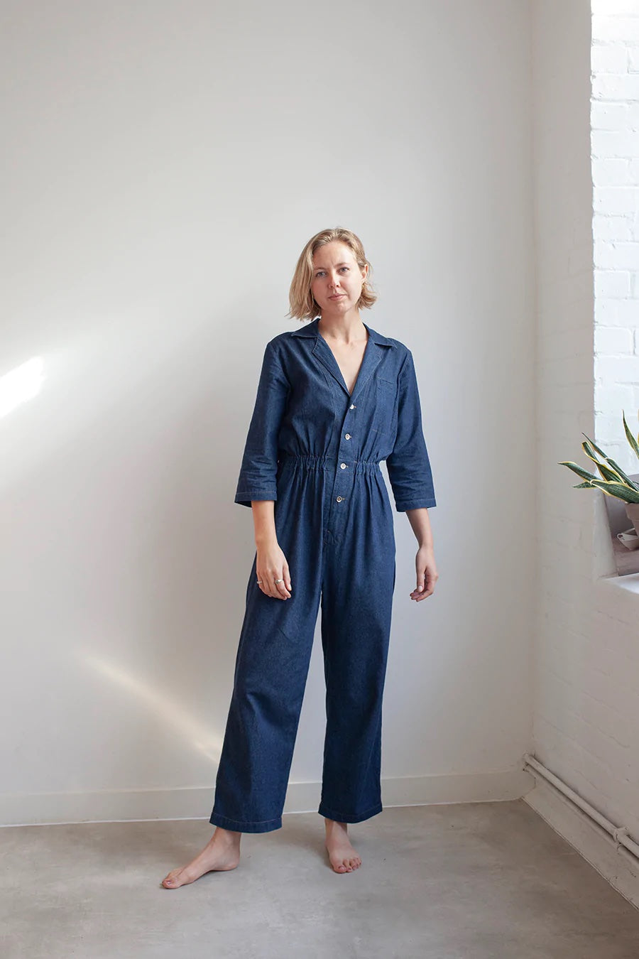 Woman wearing the Jesse Jumpsuit sewing pattern from The Modern Sewing Co on The Fold Line. A Jumpsuit pattern made in light/medium weight denim or twill, light weight canvas; needlecord, wool suiting or linen fabrics, featuring a relaxed fit, collar, dee