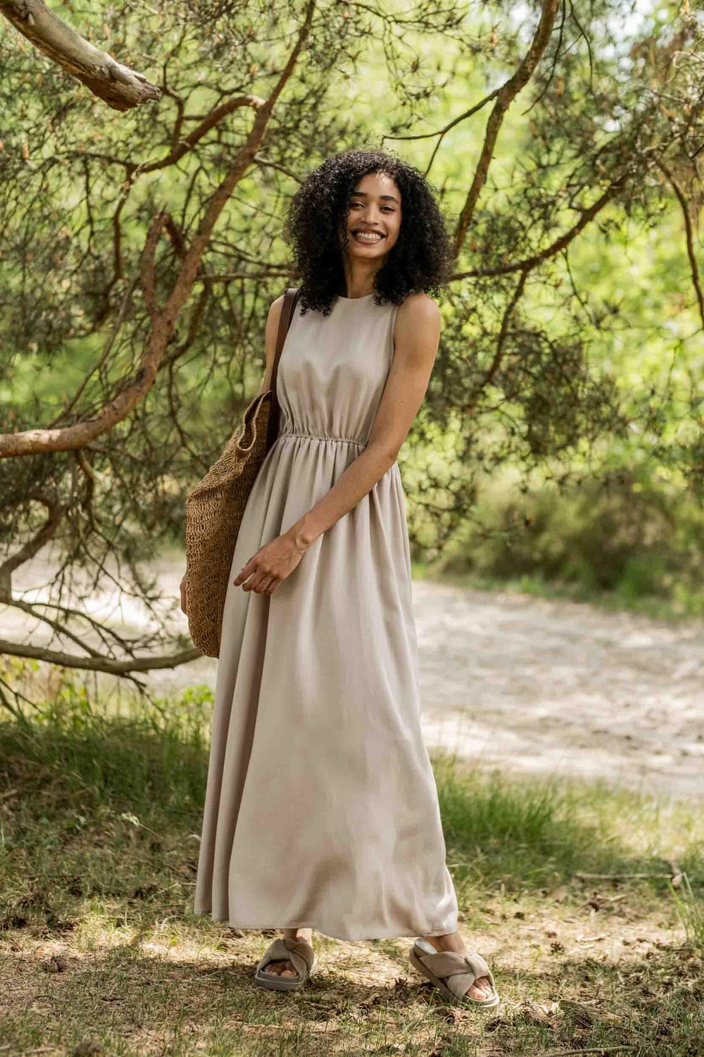 Woman wearing the Jill Dress sewing pattern from Fibre Mood on The Fold Line. A sleeveless dress pattern made in lyocell, poplin, chambray, linen, viscose (crepe), double gauze, broderie anglaise or jacquard fabrics, featuring a relaxed fit, round necklin