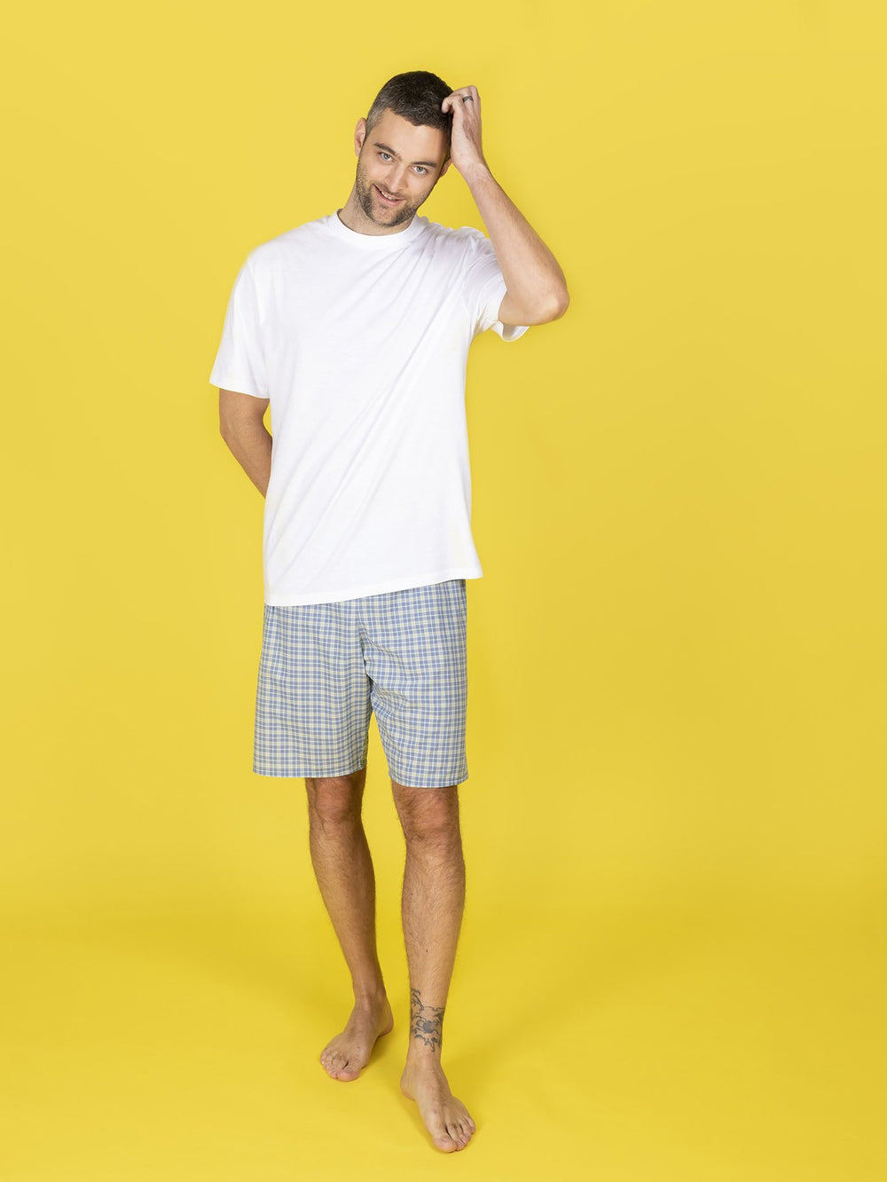 Man wearing the Joe Pyjama Shorts sewing pattern from Tilly and the Buttons on The Fold Line. A PJ shorts pattern made in cotton lawn, shirting, quilting cotton, flannel, double gauze or viscose/ rayon fabrics, featuring an above knee length, optional dra