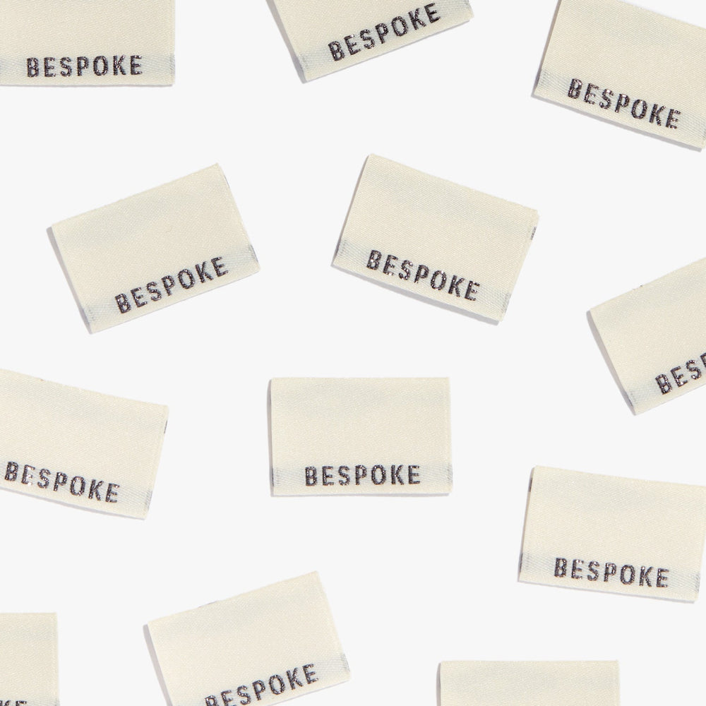 Photo showing 'Bespoke' Woven Labels from Kylie & The Machine on The Fold Line. A washable, durable and non-scratchy fabric label featuring the word 'Bespoke' all ready to be sewn into your handmade clothes.