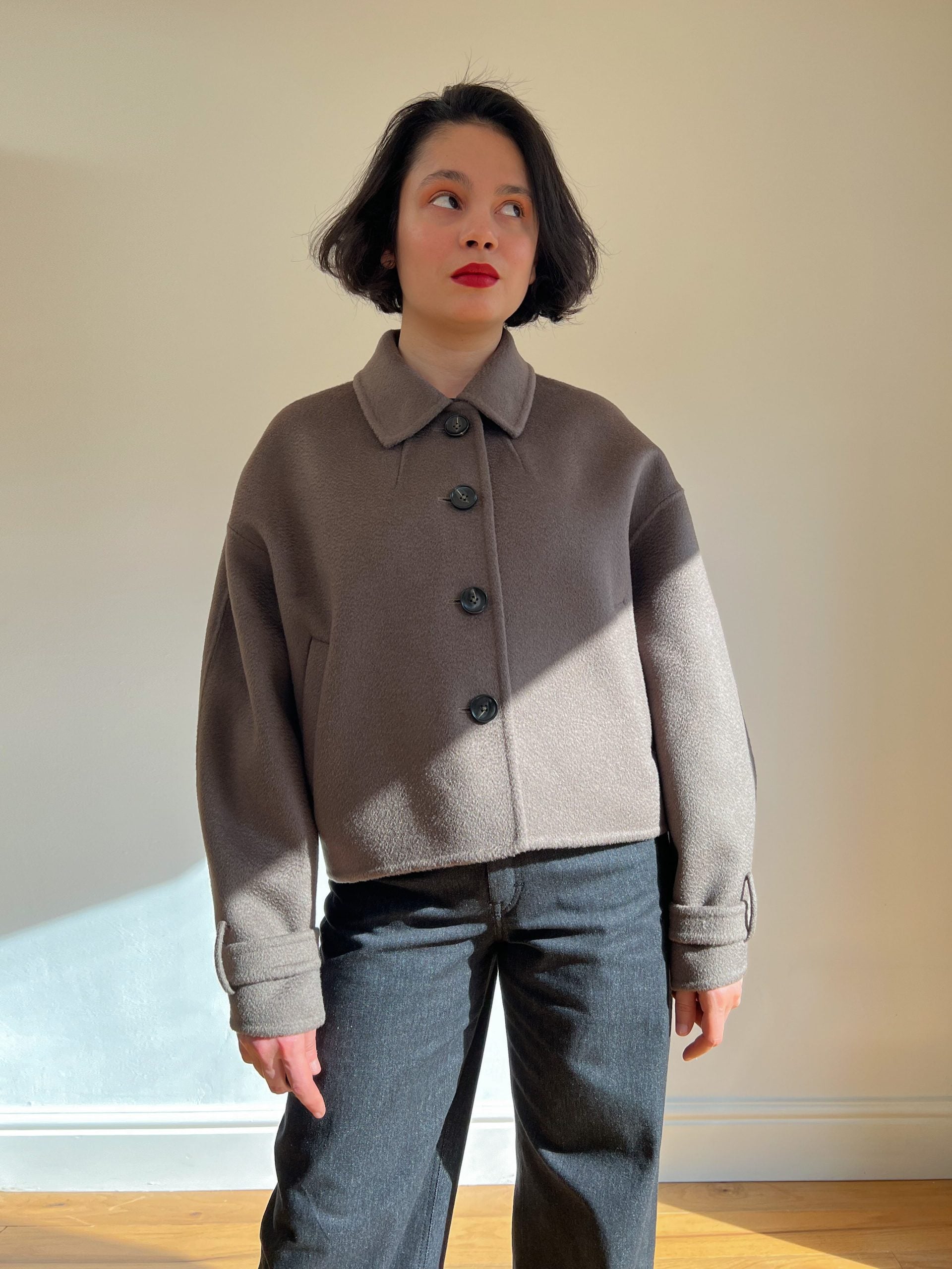 Woman wearing the Kaia Coat sewing pattern from Bella Loves Patterns on The Fold Line. A short coat pattern made in double faced coating fabric, featuring an oversized silhouette, dropped shoulder line, bal collar with a collar stand, button closure, welt