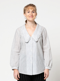 Woman wearing the Kennie Woven Shirt sewing pattern from Style Arc on The Fold Line. A shirt pattern made in cotton, voile or silk fabrics, featuring a button-front closure, bust darts, deep V-neck, large statement collar edged with a frill, and long slee