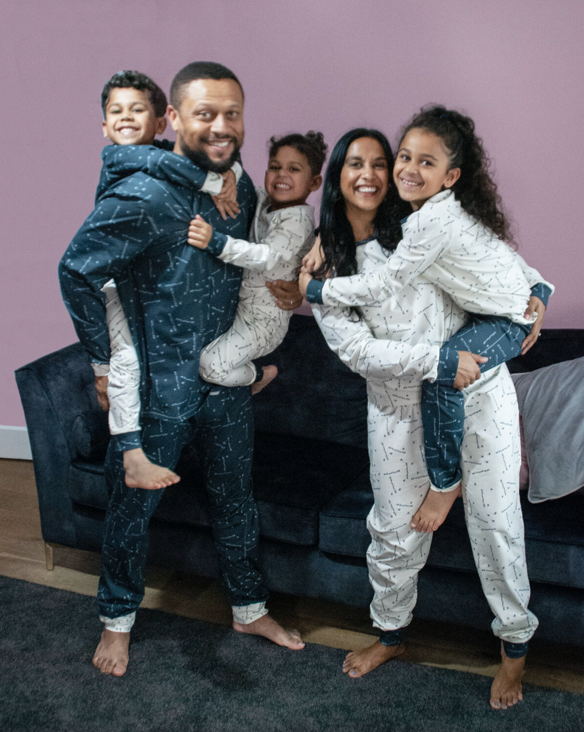Man, Woman and Children wearing the Family Perri PJs sewing pattern from Pattern Paper Scissors on The Fold Line. A pyjamas pattern made in jersey or viscose jersey fabrics, featuring a round neck top with full length sleeve and cuff, trousers have full l