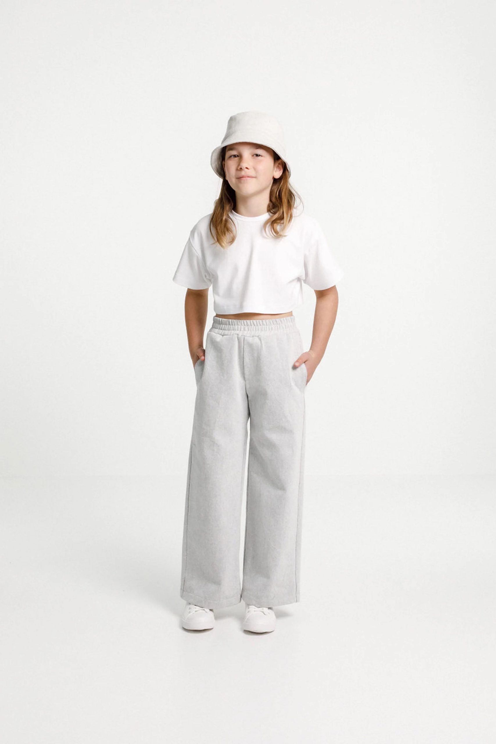 Child wearing the Child/Teen Tula Pants sewing pattern from Papercut Patterns on The Fold Line. A trouser pattern made in light to mid-weight woven or knit fabrics, linen, cotton, sweatshirting and blends fabrics, featuring an elasticated waistband, side 