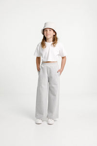 Child wearing the Child/Teen Tula Pants sewing pattern from Papercut Patterns on The Fold Line. A trouser pattern made in light to mid-weight woven or knit fabrics, linen, cotton, sweatshirting and blends fabrics, featuring an elasticated waistband, side 