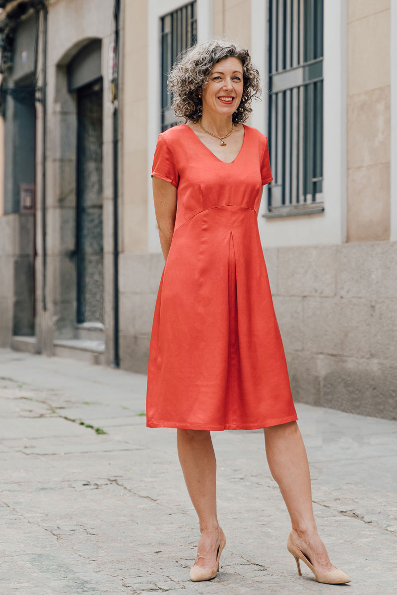 Woman wearing the Kyoto Dress sewing pattern from Liesl + Co on The Fold Line. A dress pattern made in linen, rayon, soft cottons, and sateen fabrics, featuring a semifitted, V-neck, curved waist seam, front and back darts , center front inverted box plea