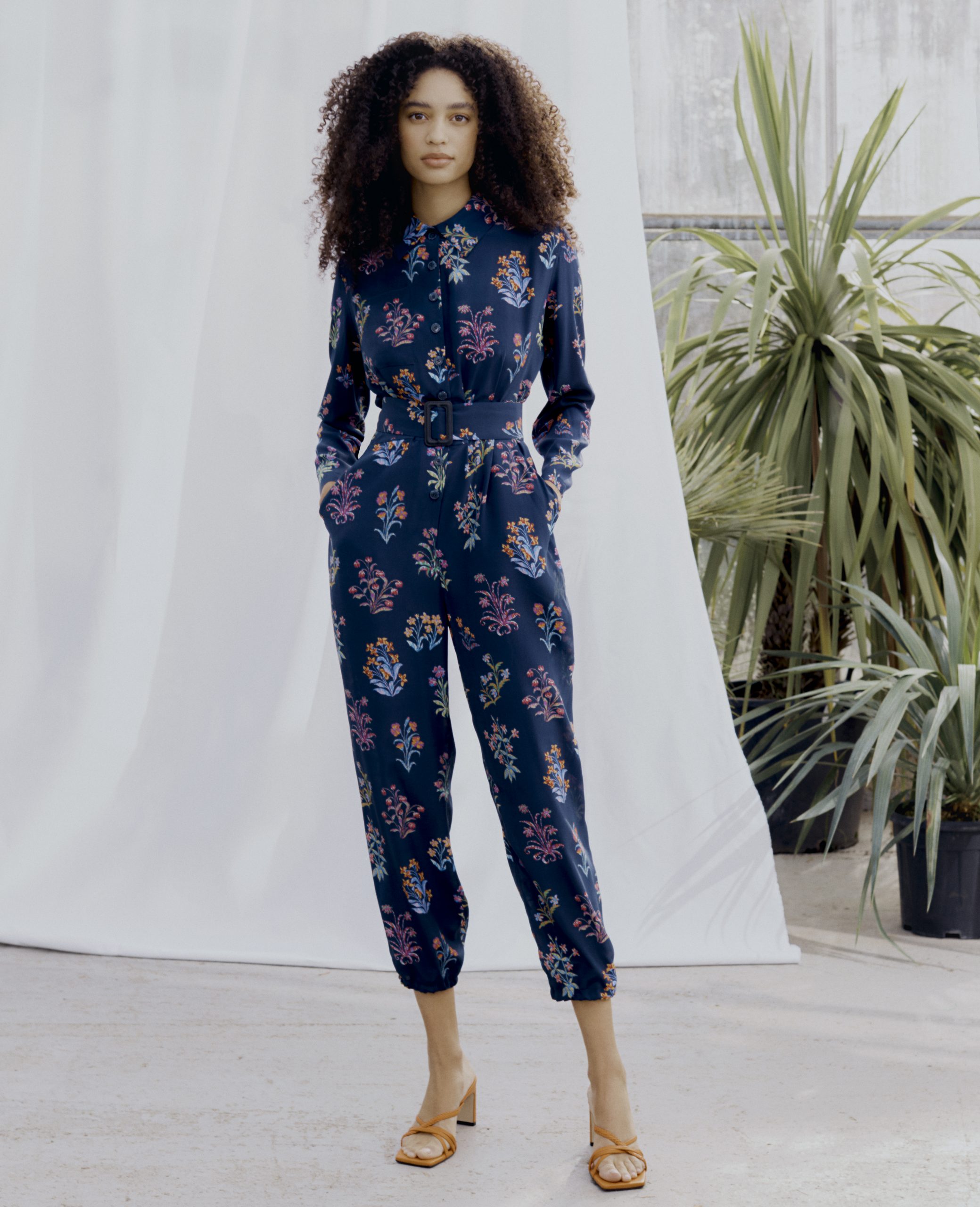 Woman wearing the Zadie Boiler Suit sewing pattern from Liberty Sewing Patterns on The Fold Line. A boilersuit pattern made in lawn cotton, crepe de chine, twill, denim or linen fabrics, featuring front button closure, cropped length, full length sleeves,