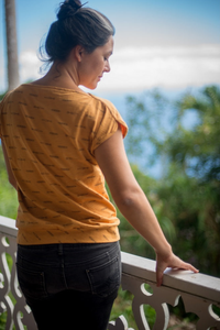 Woman wearing the La Brea Tee sewing pattern from Halfmoon Atelier on The Fold Line. A T-shirt pattern made in 100% cotton, linen, hemp or modal knit fabrics, featuring short grown-on sleeves, bound necklines, French seams and bias facing.