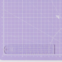 Photo of the Label Placement Ruler from Little Rosy Cheeks on The Fold Line. A transparent acrylic ruler marked in centimetres and inches to achieve sewing label placement perfection.