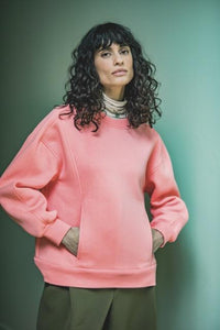 Woman wearing the Lara Sweater sewing pattern from Fibre Mood on The Fold Line. A jumper pattern made in sweatshirting fabric, french terry, scuba, knit jacquard, or punta di roma, featuring an oversized fit, unique style lines perfect for colour blocking