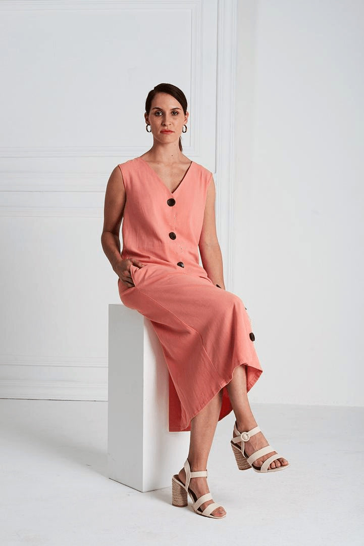 Woman wearing the Lea Dress pattern from Pattern Sewciety on The Fold Line. A sleeveless dress pattern made in cotton, cotton blends, linen, linen blends, chambray or silk fabrics, featuring front button closure, bust darts, V-neck, waist seam, in-seam po