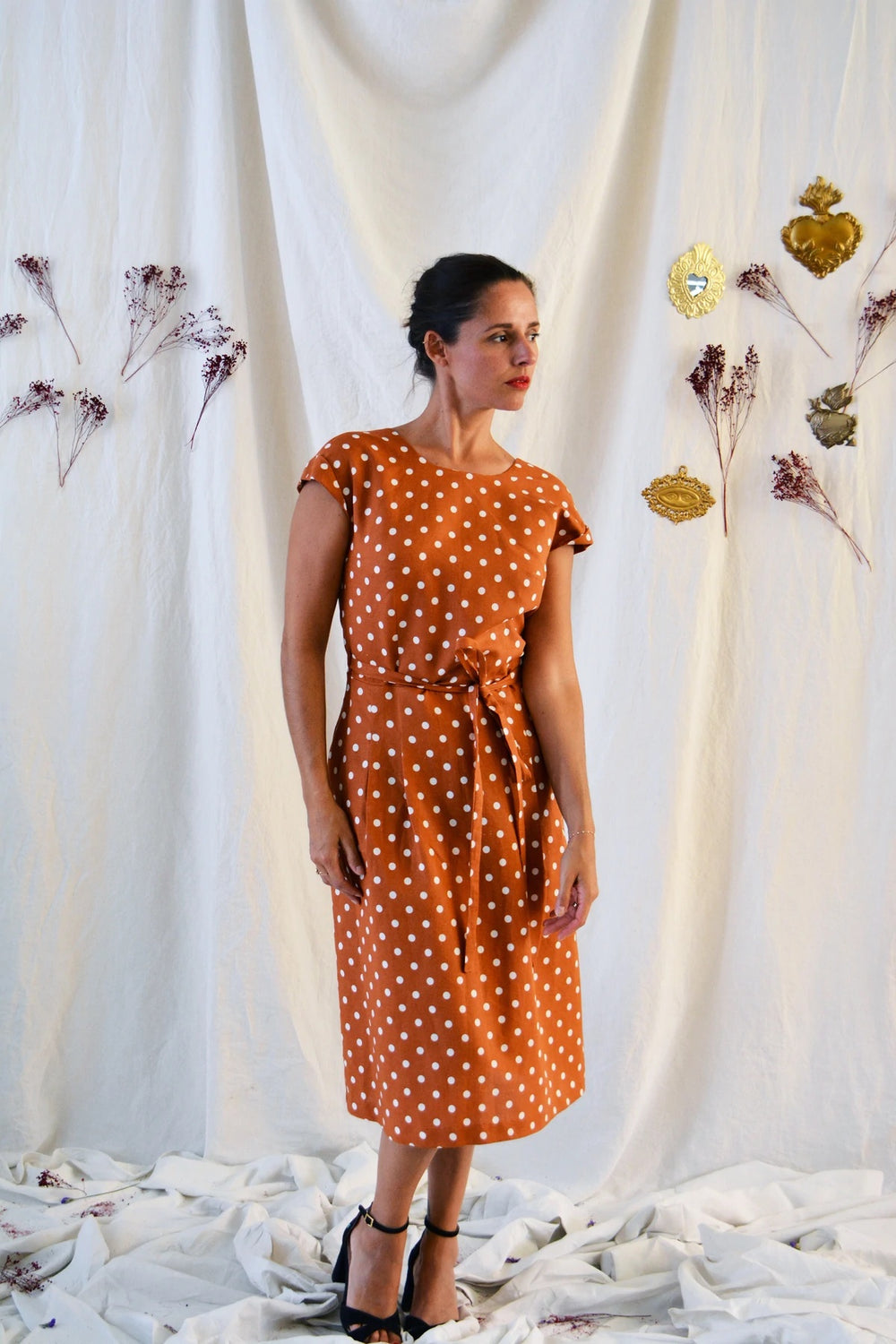 Woman wearing the Leaf Dress sewing pattern from Maison Fauve on The Fold Line. A dress pattern made in viscose, cotton, satin, crepe or lace fabrics, featuring a round neck at the front, back crossover V-neckline, bust darts, grown-on cap sleeves, midi l