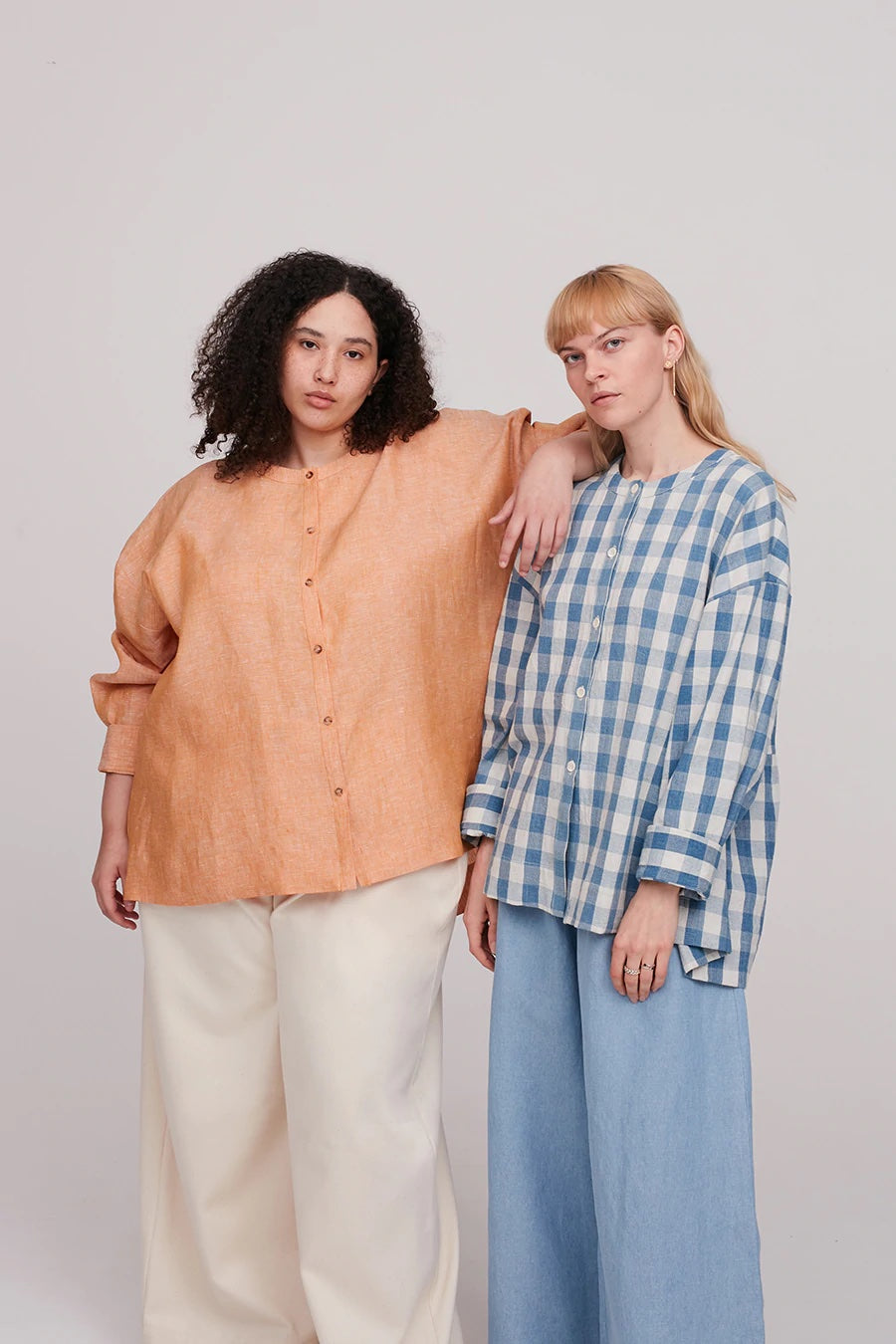 Women wearing the Leila Shirt sewing pattern from The Modern Sewing Co on The Fold Line. A shirt pattern made in poplin, muslins, linens, tencels or silk fabrics, featuring a loose fit, very dropped shoulders, full length sleeves, button front closure and