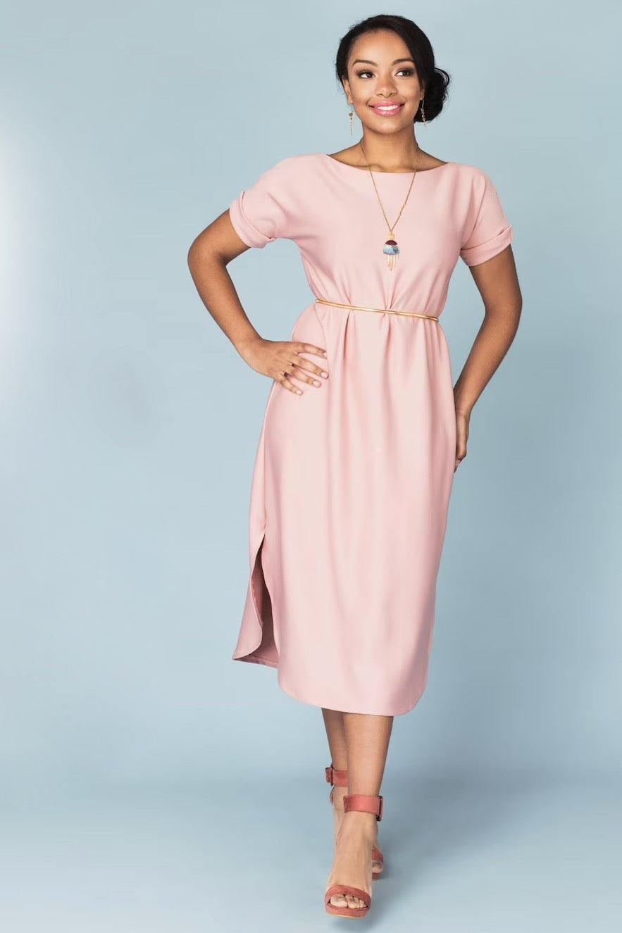 Woman wearing the Lemon Drop Dress sewing pattern from Our Lady of Leisure on The Fold Line. A dress pattern made in stretch knit fabrics, featuring a boat neck, folded sleeve hem, relaxed fit, midi length, and curved hem with side slits.