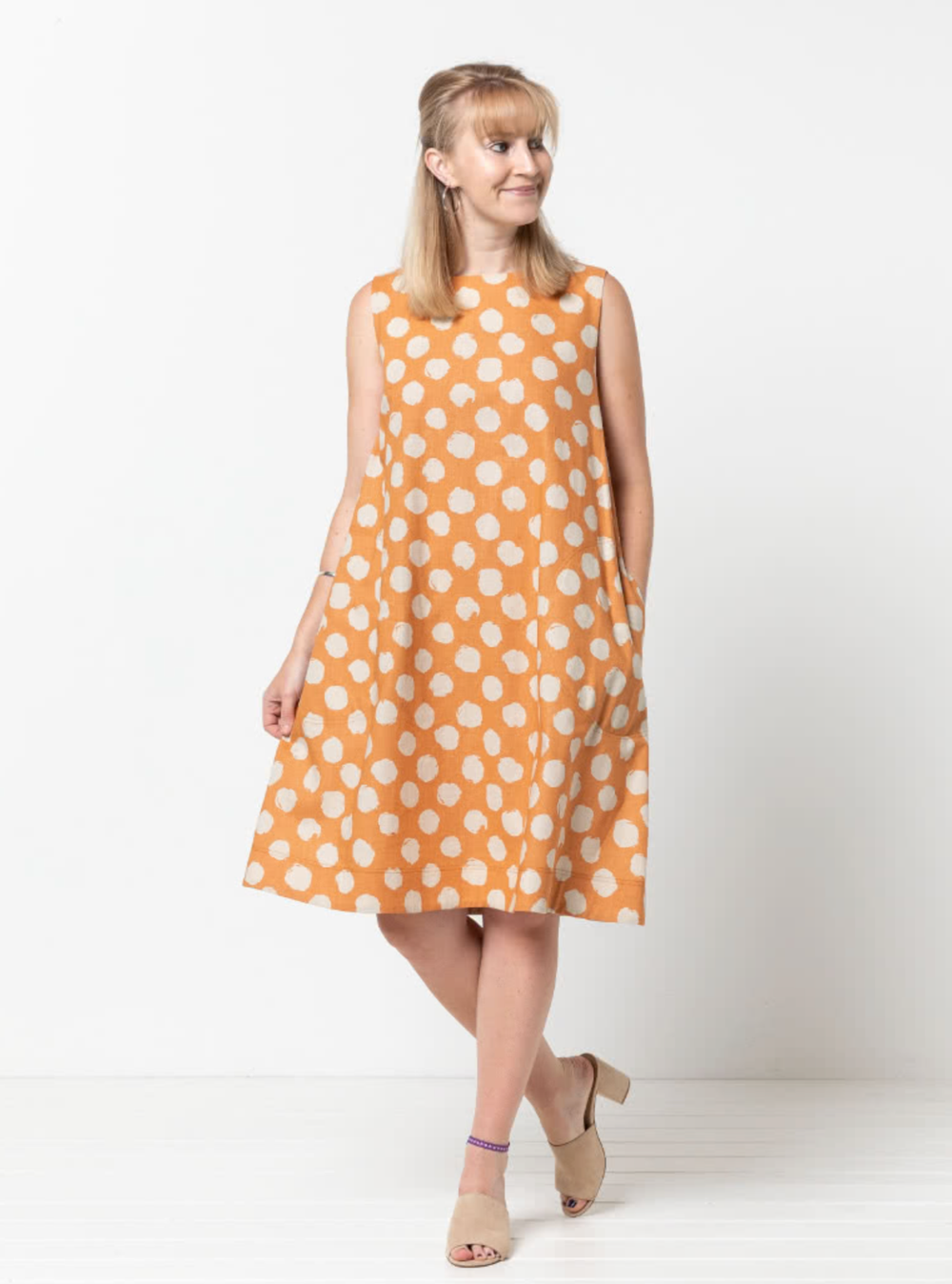 Woman wearing the Lena Shift Dress sewing pattern from Style Arc on The Fold Line. A shift dress pattern made in cotton, linen, or crepe fabrics, featuring an A-line silhouette, sleeveless, boat neck, large side pockets, and below knee length.