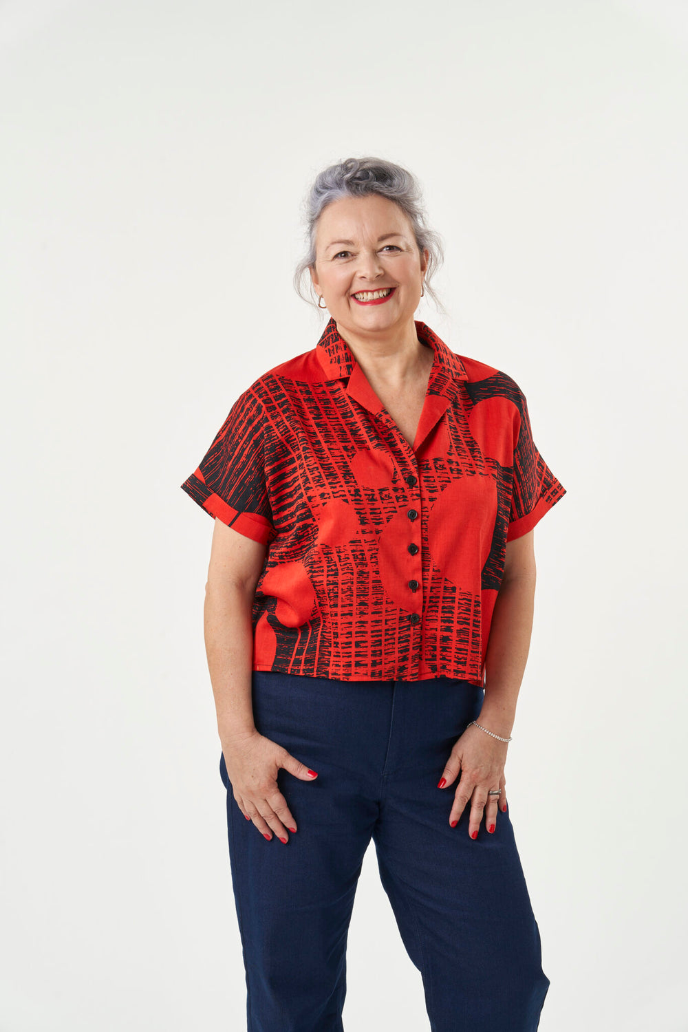 Woman wearing the Libby Shirt sewing pattern from Sew Over It on The Fold Line. A shirt pattern made in rayon, viscose and crepe fabrics, featuring a boxy, loose fit, cropped hem, notched collar, button front closure, gathered back yoke, and short grown o