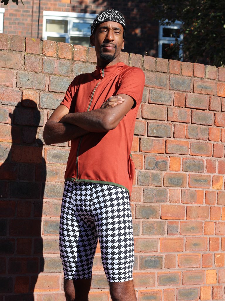 Man wearing the Men's Lightspeed Leggings sewing pattern from Fehr Trade on The Fold Line. A leggings pattern made in lycra fabric, featuring a roomy front pouch, rear panel with zippered pocket, elasticated waistband, and above knee length.