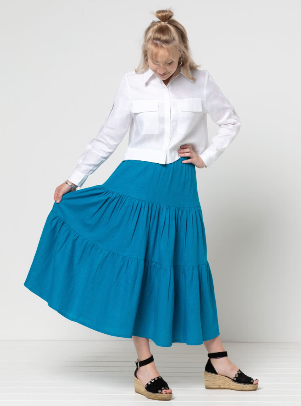 Woman wearing the Lila Tiered Skirt sewing pattern from Style Arc on The Fold Line. A Skirt pattern made in silk, rayon, crepe or washed linen fabrics, featuring a midi length, three gathered tiers and elasticated waist.