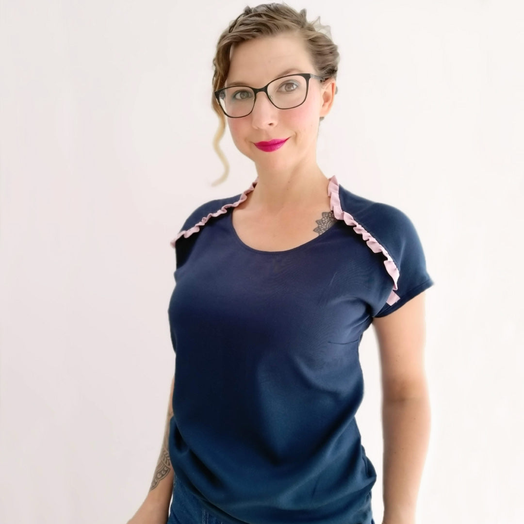 Woman wearing the Lily Top sewing pattern by Experimental Space. A top pattern made in rayon, viscose or crepe fabrics, featuring a short drop sleeve with a pretty ruffle detail starting mid-way up the sleeve, curving as it reaches the neck.
