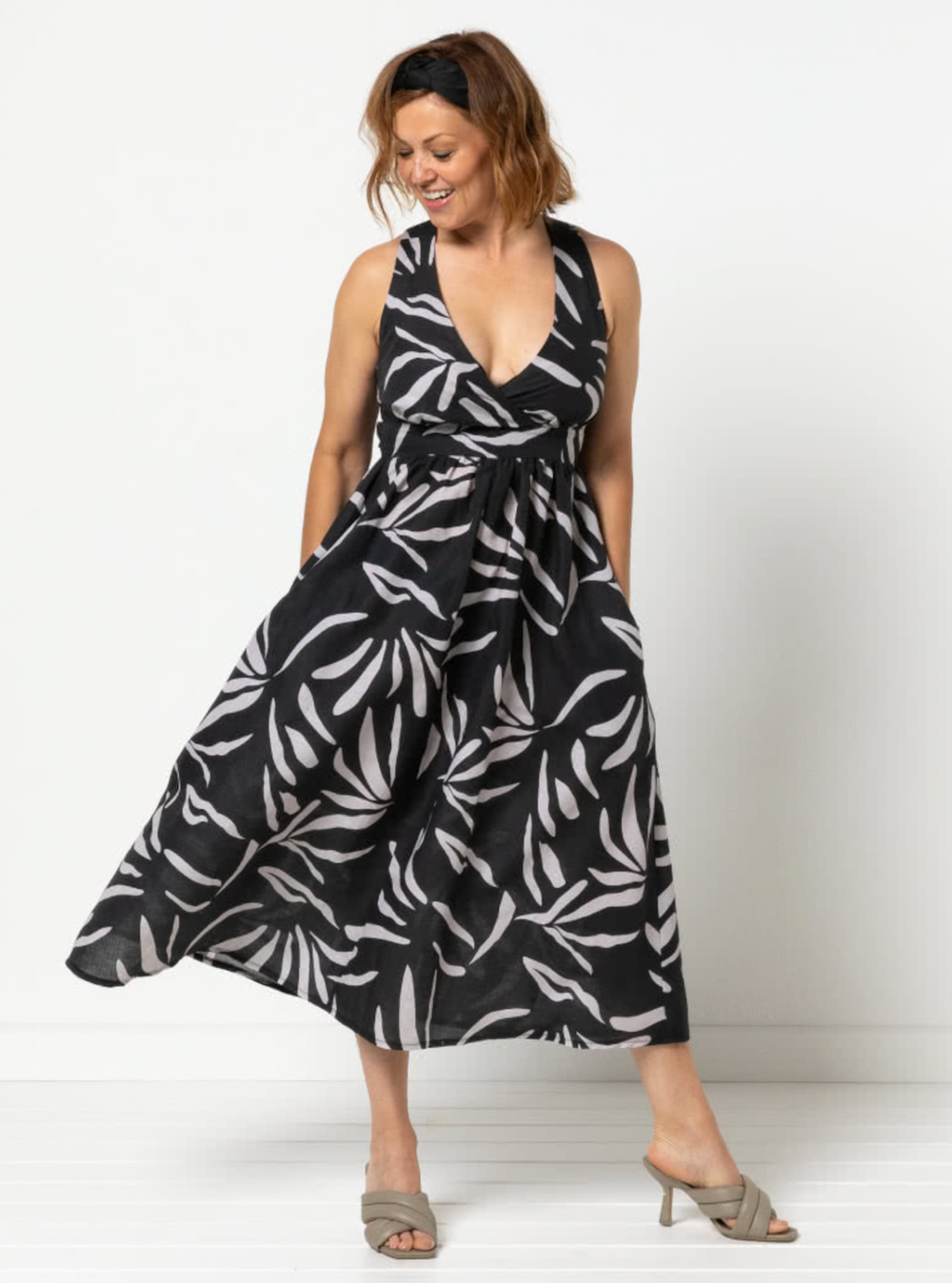 Woman wearing the Livvy Woven Dress sewing pattern from Style Arc on The Fold Line. A sundress pattern made in cotton, rayon, silk, or lightweight linen fabric, featuring a crossover front with a deep v neck, shirred back, straight or crossed straps, wais