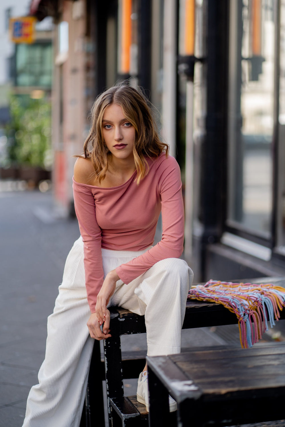 Woman wearing the Liza Top sewing pattern from JULIANA MARTEJEVS on The Fold Line. A tee pattern made in cotton jersey fabrics, featuring long sleeves with single cold shoulder and slanting neckline.