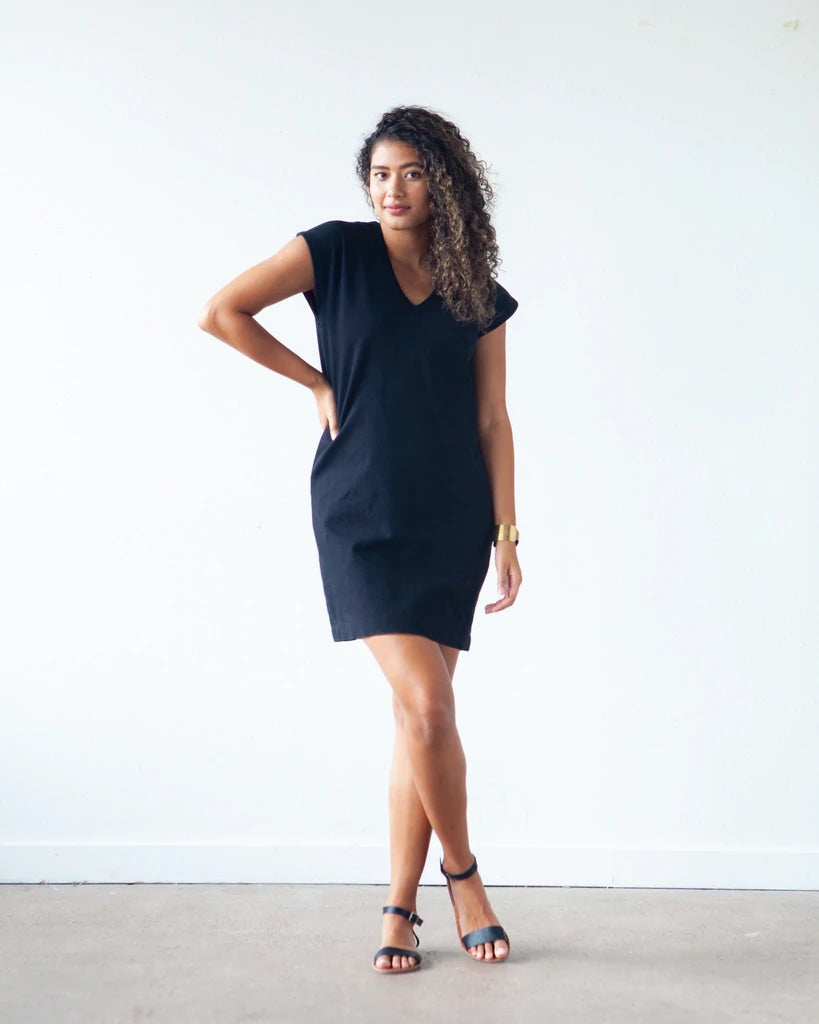 Woman wearing the Lodo Dress sewing pattern from True Bias on The Fold Line. A dress pattern made in medium weight stable knit fabrics, featuring a straight fit through the waist and hips, slightly tapered hem to create a subtle cocoon shape, V neck at ce