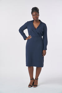 Woman wearing the Lois Dress sewing pattern from Sew Over It on The Fold Line. A dress pattern made in viscose and crepe fabrics, featuring a pleat and dart shaped bodice, faux-wrap, V-neck, collar and collar stand, long sleeves with cuffs, elasticated ba
