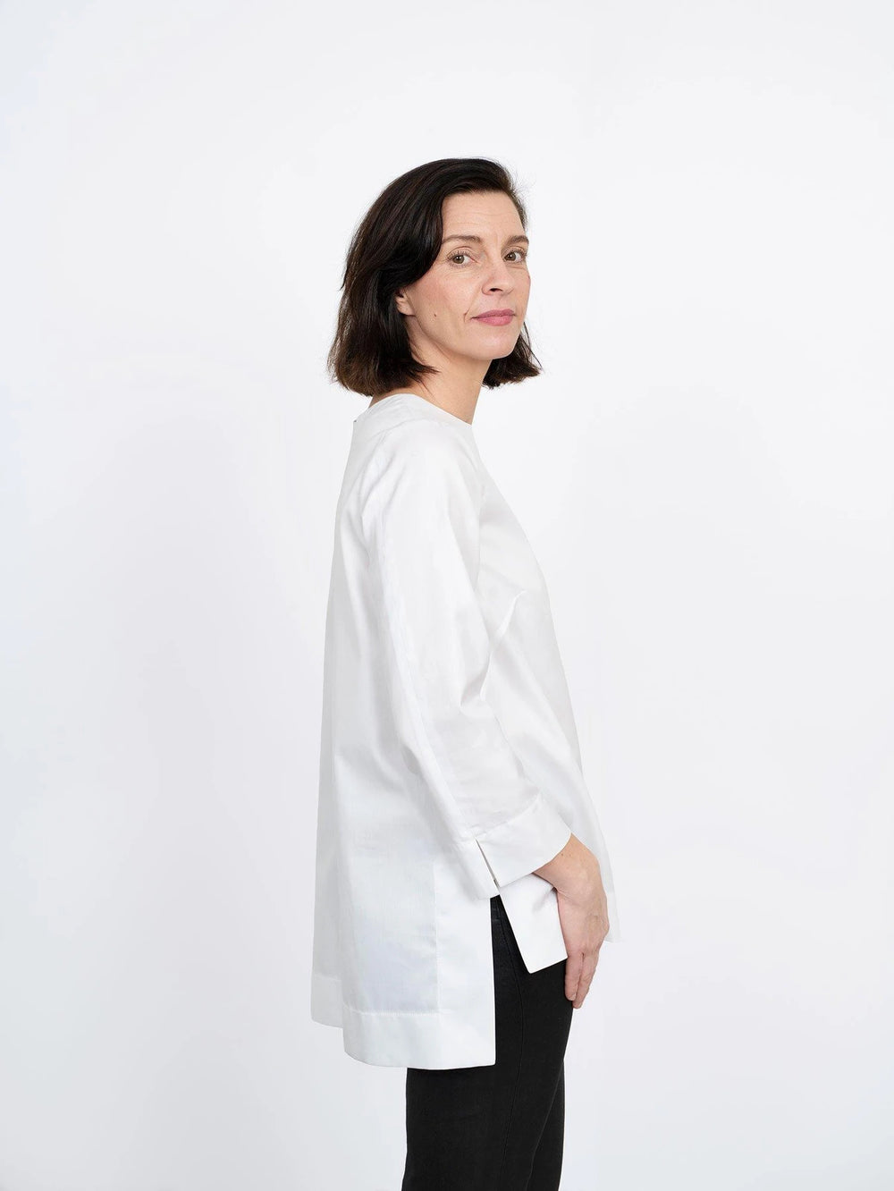Woman wearing the Long Sleeve Tunic sewing pattern from The Assembly Line on The Fold Line. A tunic pattern made in light to medium weight fabrics such as cotton, featuring a straight silhouette, invisible back zipper, hem and sleeve hem slits, back hem l