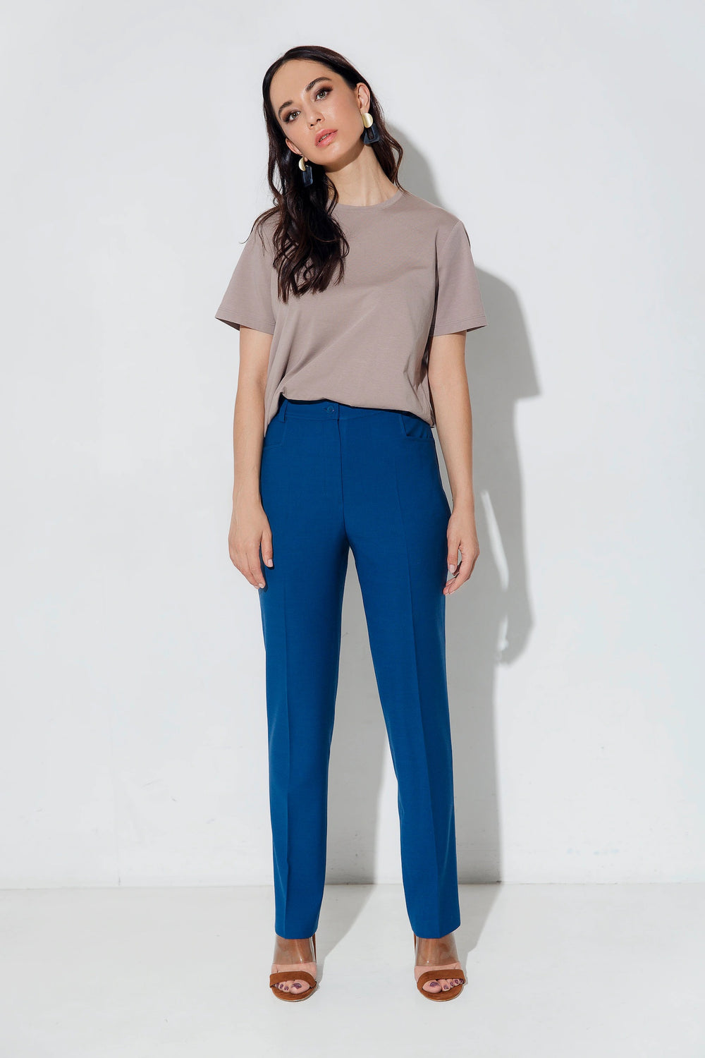 Woman wearing the Lora Trousers sewing pattern from Vikisews on The Fold Line. A trouser pattern made in medium weight woven fabrics, featuring a semi-slim fit, slightly tapered legs, waistband fastens with button and buttonhole, five belt loops, fly fron