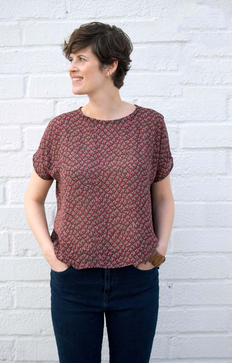 Woman wearing the Lou Box Top sewing pattern from Sew DIY on The Fold Line. A top pattern made in crepe de chine, chiffon, georgette or jersey fabrics, featuring a loose fit, straight hem, breast patch pocket, round neck and short grown on sleeves.