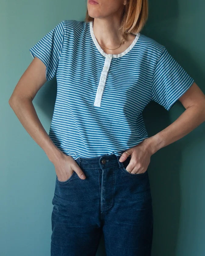 Woman wearing the Lucien Henley sewing pattern from French Navy on The Fold Line. A top pattern made in jersey, ribbed knit, sweater knit, or ponte roma fabrics, featuring a simi fitted silhouette, set-in short sleeves, front button placket and neck bindi