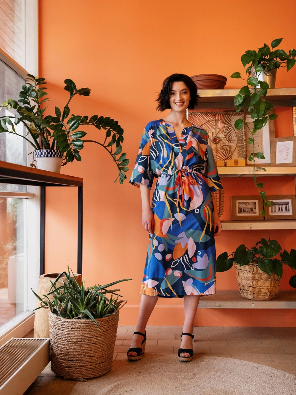 Woman wearing the Lynn Caftan Dress sewing pattern from Atelier Jupe on The Fold Line. A dress pattern made in viscose, cotton, linen or jersey fabrics, featuring a relaxed fit, large popover placket, wide sleeves, waist casing with ribbon and midi length