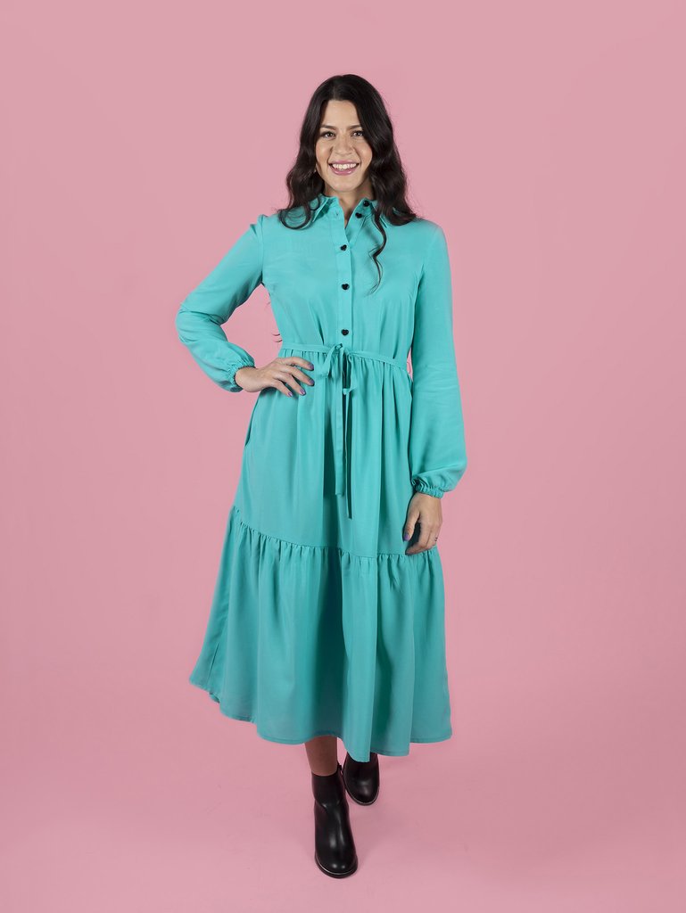 Woman wearing the Lyra Shirt Dress sewing pattern by Tilly and the Buttons. A dress pattern made in light to medium weight woven fabrics, featuring a button front opening, side seam pockets, long billowy sleeves with elasticated cuffs, side seam pockets a
