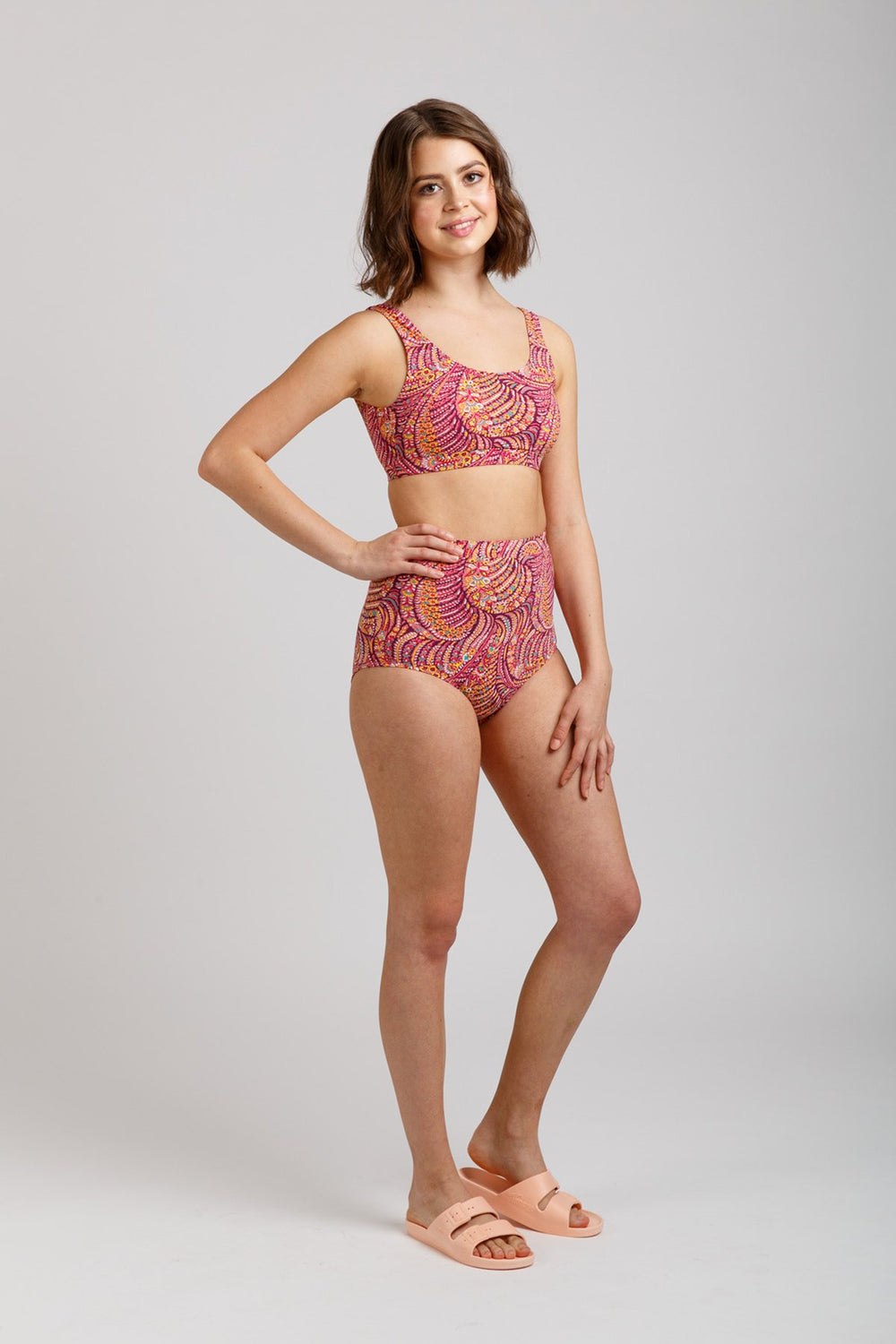 Woman wearing the Cottesloe Bikini sewing pattern from Megan Nielsen on The Fold Line. A bikini pattern made in swimsuit fabrics, featuring a scoop neckline, no fastening, underbust band and high waisted, low rise, full coverage bikini bottoms.
