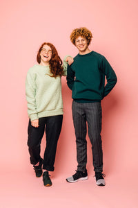 Man and woman wearing the Maggi Sweater sewing pattern from Melilot on The Fold Line. A unisex sweater pattern made in ponte, double knit, sweatshirt fleece, french terry, jersey or sweater knit fabrics, featuring a relaxed fit, raglan sleeves, cuff, neck