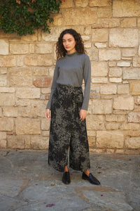 Woman wearing the Magnolia Pants sewing pattern from The Patterns Room on The Fold Line. A trouser pattern made in soft linen, viscose, light denim or crepe fabrics featuring a wide leg with extra front skirt layer tied at the left side, elasticated back 