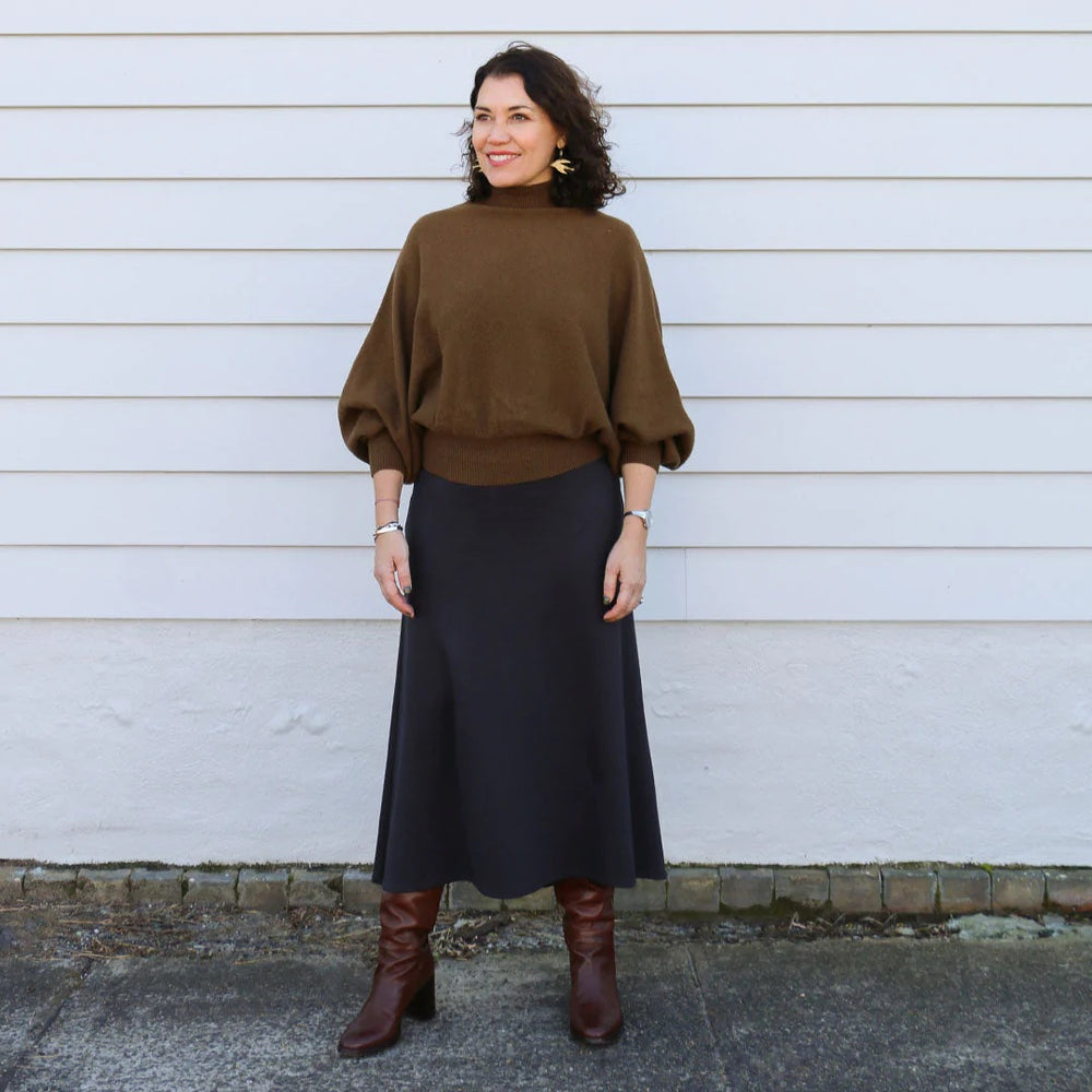 Woman wearing the Mahlia Skirt sewing pattern from Tessuti Fabrics on The Fold Line. A skirt pattern made in ponti knit, stretch velvet jersey or viscose/elastane jersey fabrics, featuring an A-line silhouette, fitted through the waist and hips, subtle cu